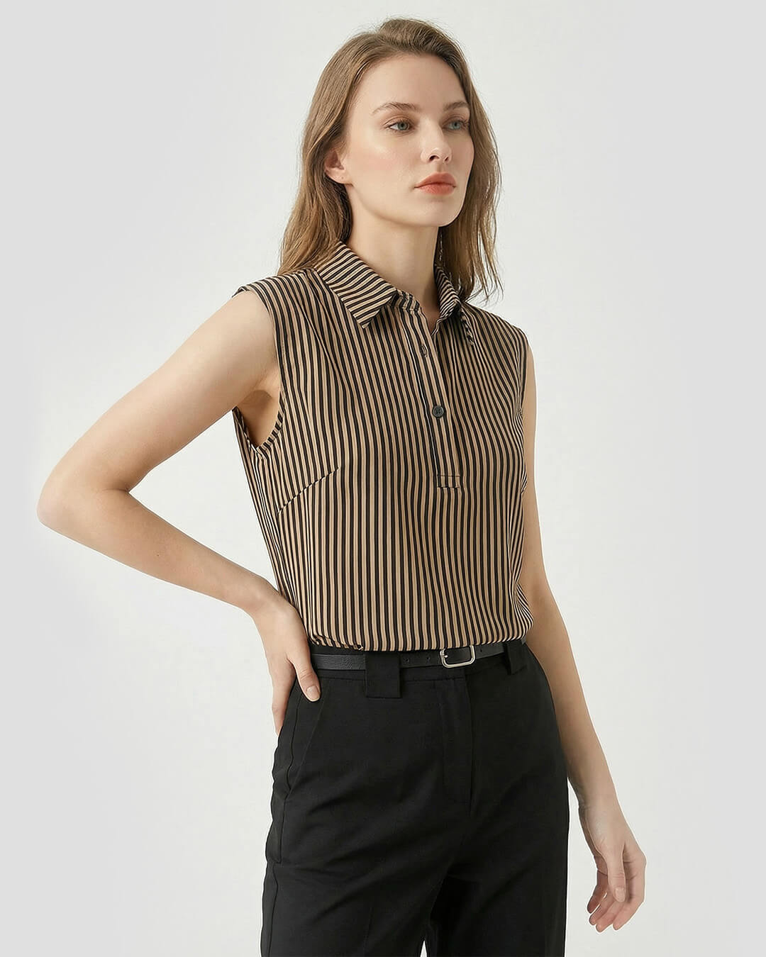 Woman wearing a sleeveless striped shirt and black pants on a white background- sfosh