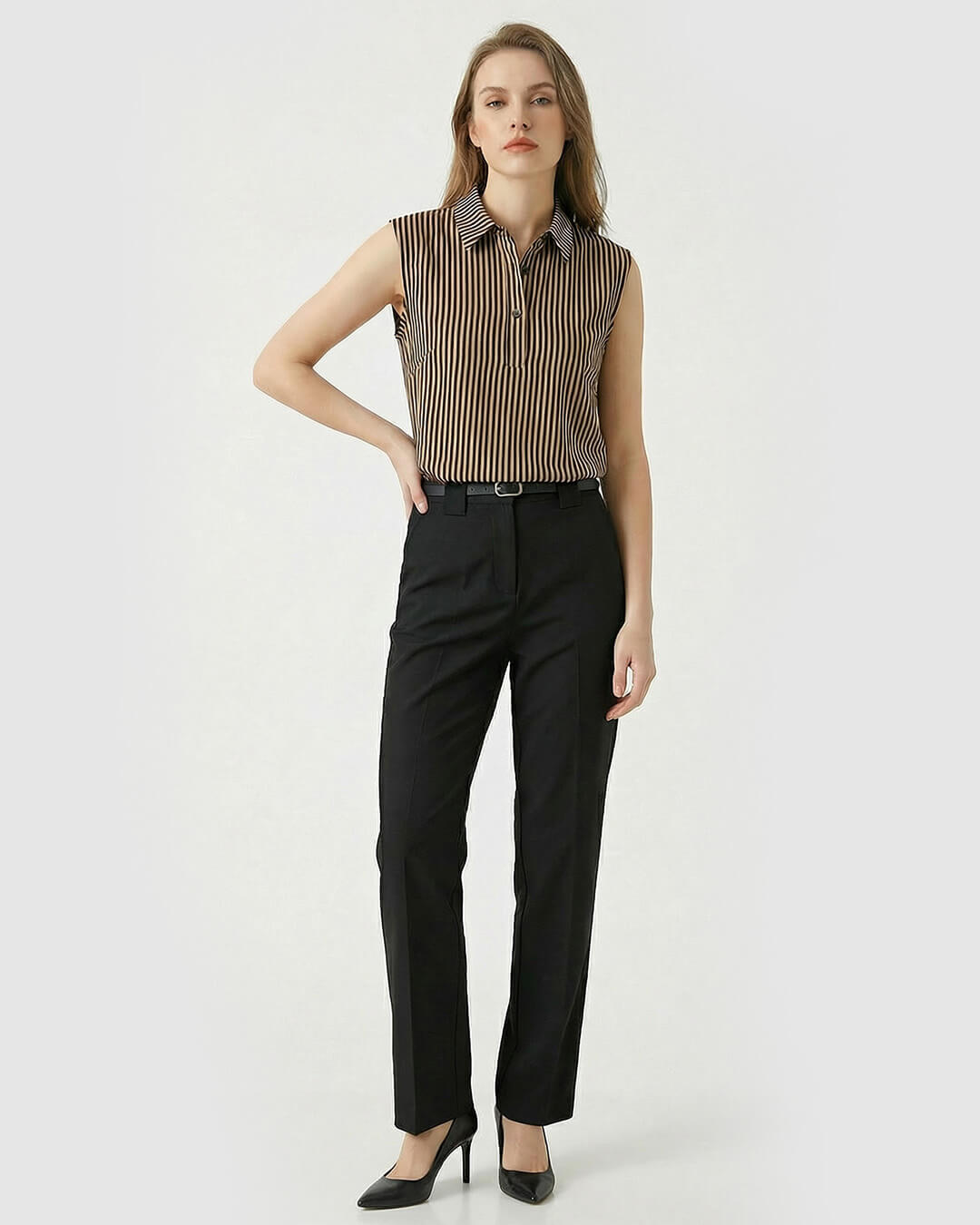 Woman wearing a sleeveless striped shirt and black pants on a white background- sfosh
