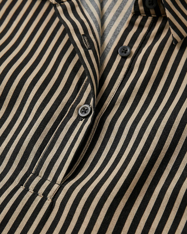 Close-up of a black and beige striped shirt with buttons.- sfosh