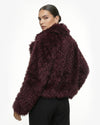 Woman wearing a dark purple fluffy jacket on a white background - sfosh