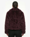 Person wearing a dark purple fluffy jacket on a white background - sfosh