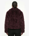 Person wearing a dark purple fluffy jacket on a white background - sfosh